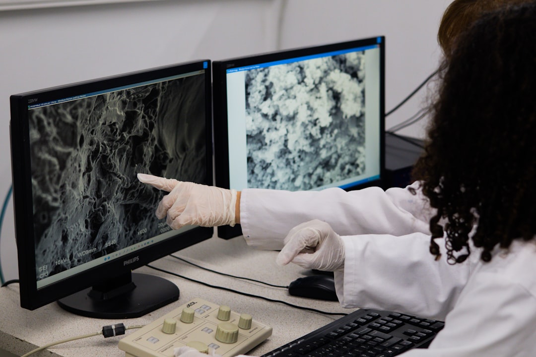 ai healthcare — ai healthcare — scientist in lab using AI-powered drug discovery software on large monitor