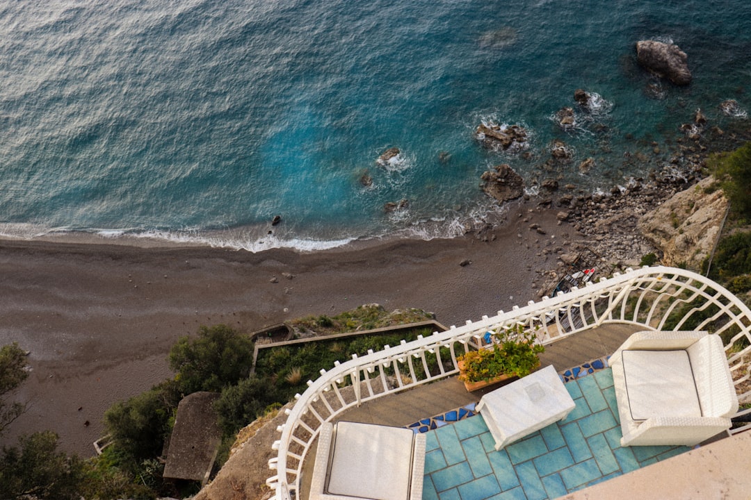 luxury travel trends redefining — a private villa terrace overlooking the Amalfi Coast at sunset with a personal concierge service setup