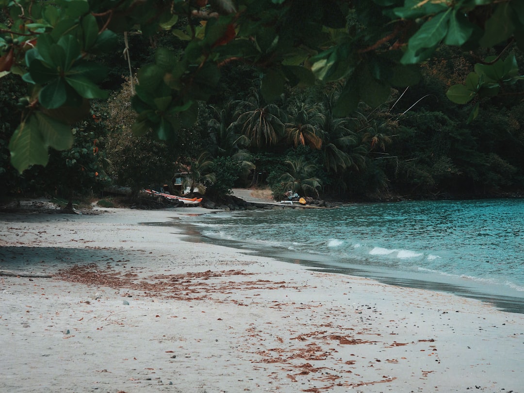 hidden coastal destinations asia — turquoise water lapping a deserted white-sand beach with dense jungle behind