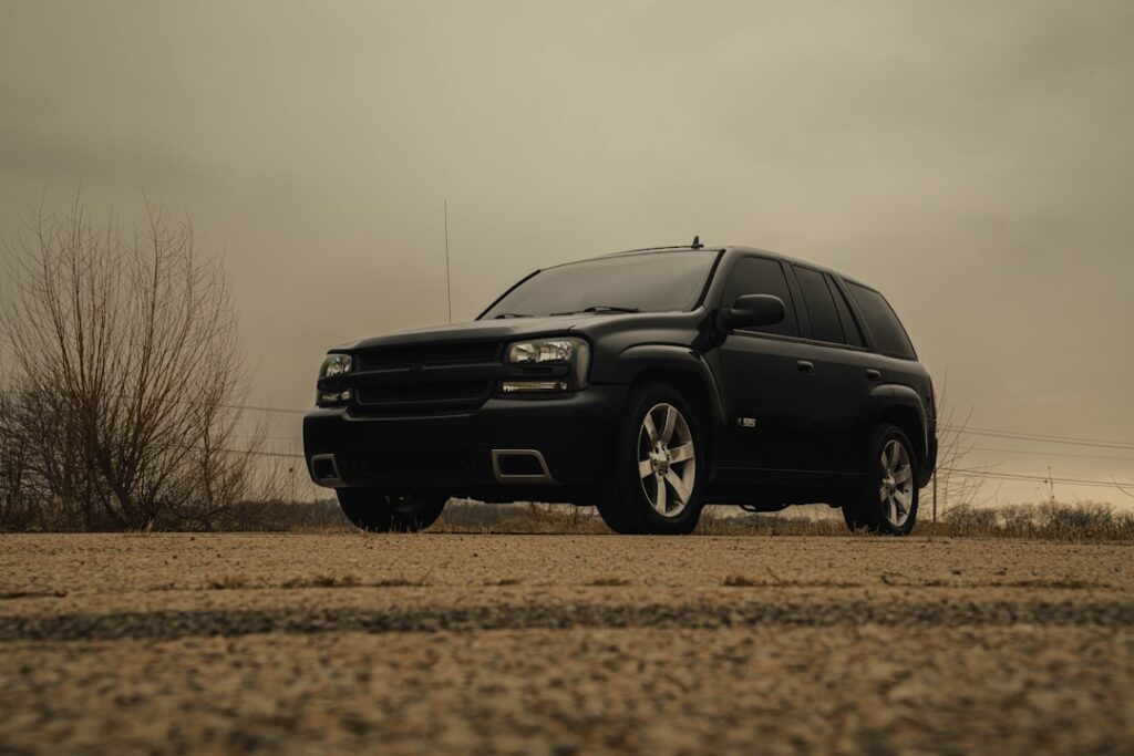 A black suv parked on a dirt road