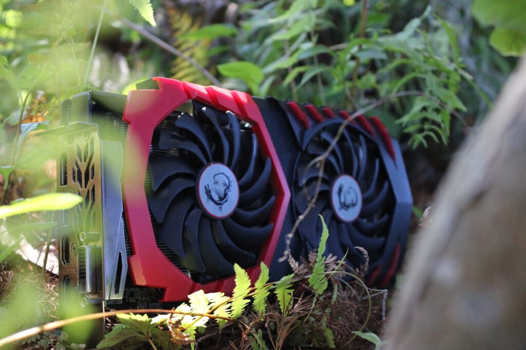 Red graphics card with black fans in foliage