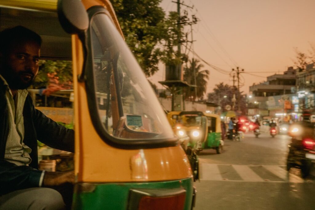 Tuk-tuk driver in traffic at dusk