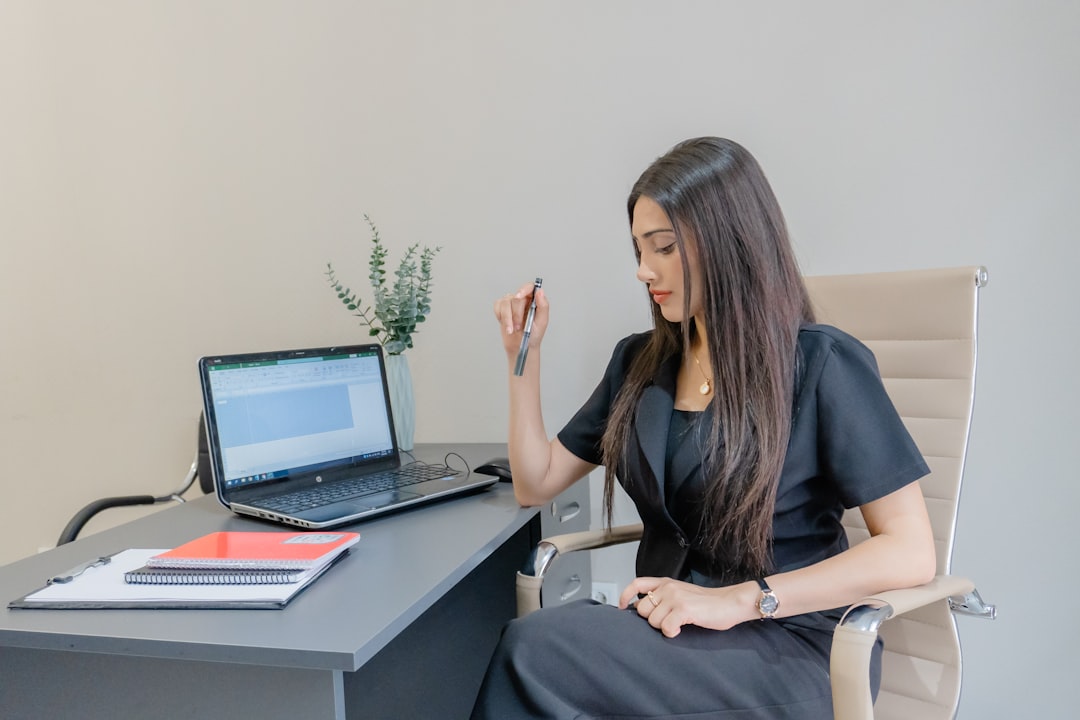 rise skill-based hiring means — professional sitting at desk reviewing digital assessment on laptop during interview