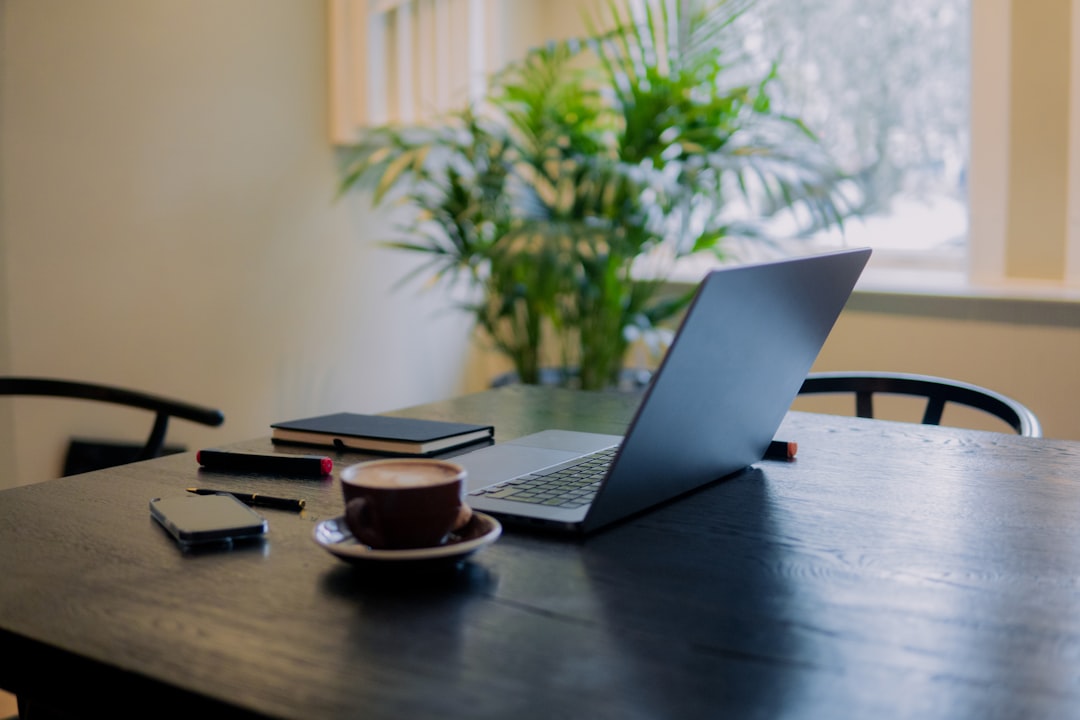 growing popularity hybrid living — employee at coworking space with laptop and coffee in morning light