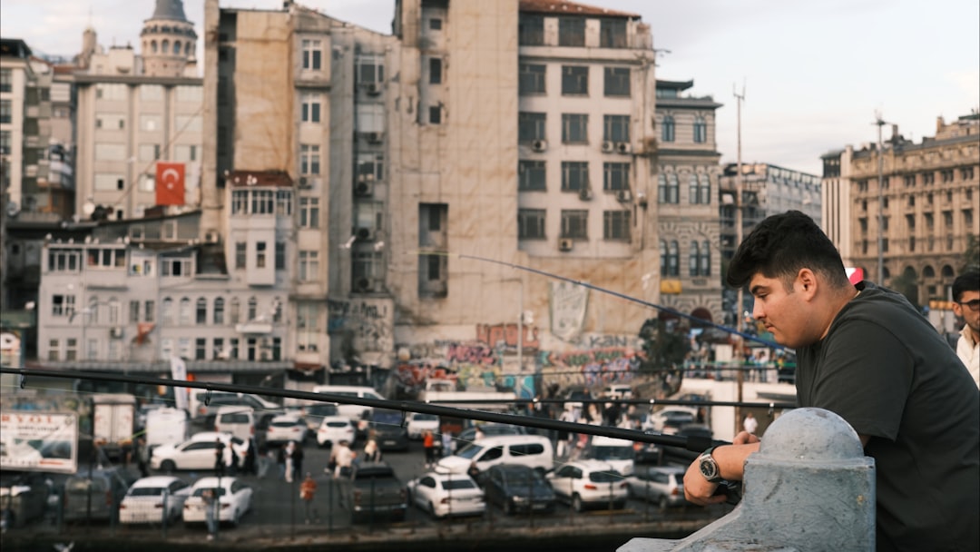 growing popularity hybrid living — person working on laptop at a cafe table with city street visible in background
