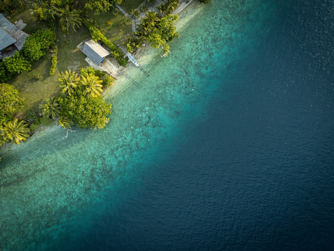 off-season luxury travel popular — aerial view of a private resort on a quiet tropical island with turquoise waters