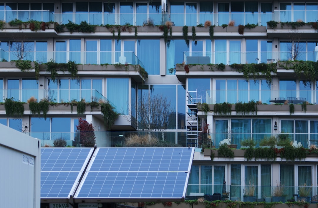rise eco-conscious hotels sustainable — panoramic view of modern eco-resort with solar panels and greenery