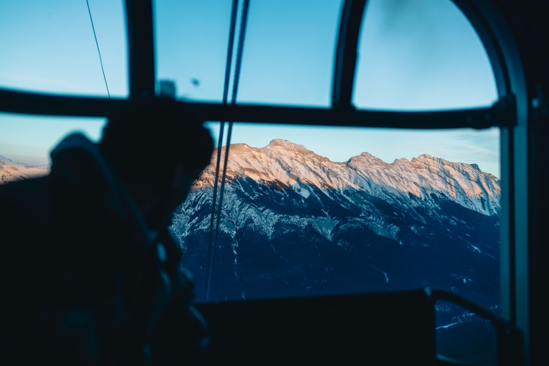 train travel comeback among — sunrise over Alpine mountain range from train window