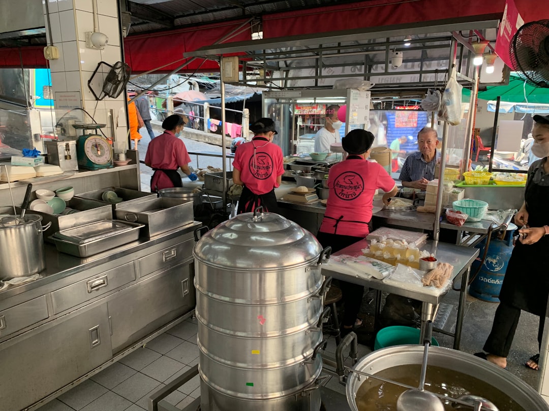 food tourism continues grow — tourists learning to cook pad thai in a Bangkok culinary classroom