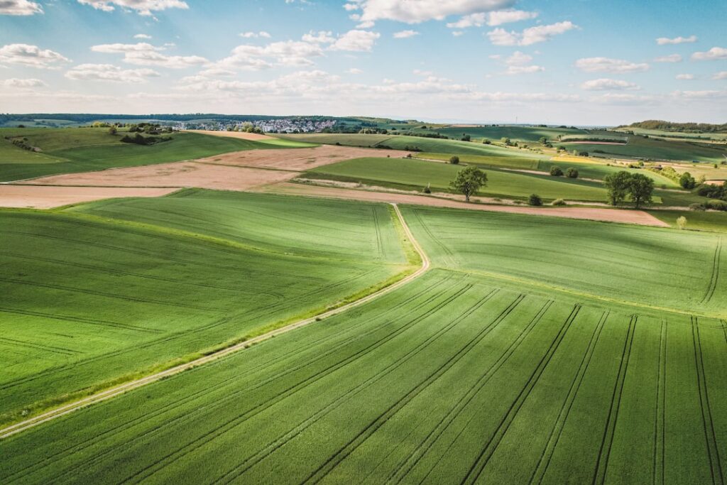 drone technology agriculture infrastructure — drone hovering over crop fields