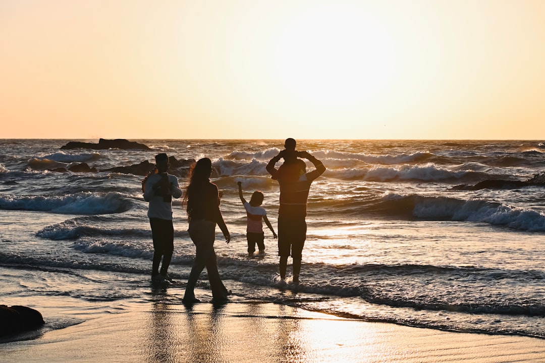 future multi-generational travel experiences — grandparents, parents, and children laughing on a beach sunset