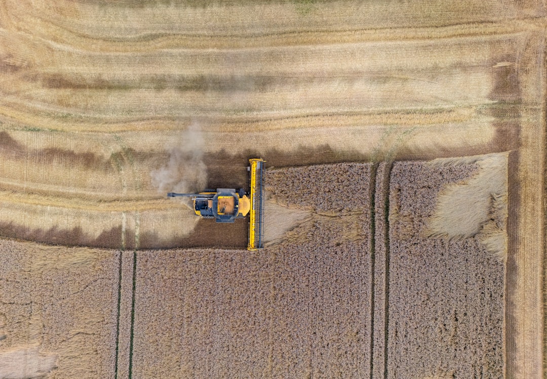 drone technology agriculture infrastructure — farmer monitoring crop field with multispectral drone data on tablet device
