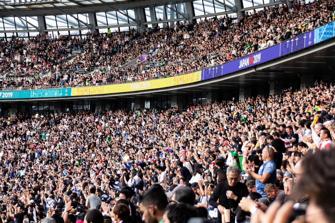 growing global business professional — esports stadium packed with thousands of cheering fans during live tournament broadcast