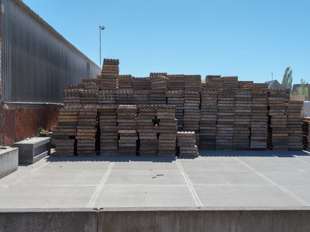 modular construction ground global — industrial factory floor with prefabricated modules stacked on pallets ready for transport