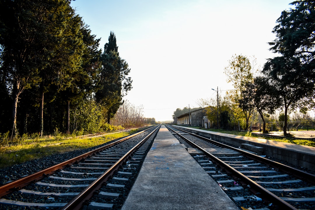 high-speed rail transform regional — construction workers on railroad tracks in sunlight