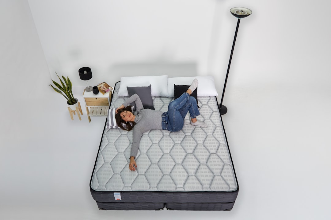 sleep technology major consumer — bedroom with smart mattress displaying temperature control on mobile app