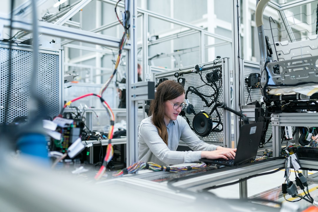 global manufacturers production closer — factory workers in a modern automotive facility assembling component parts