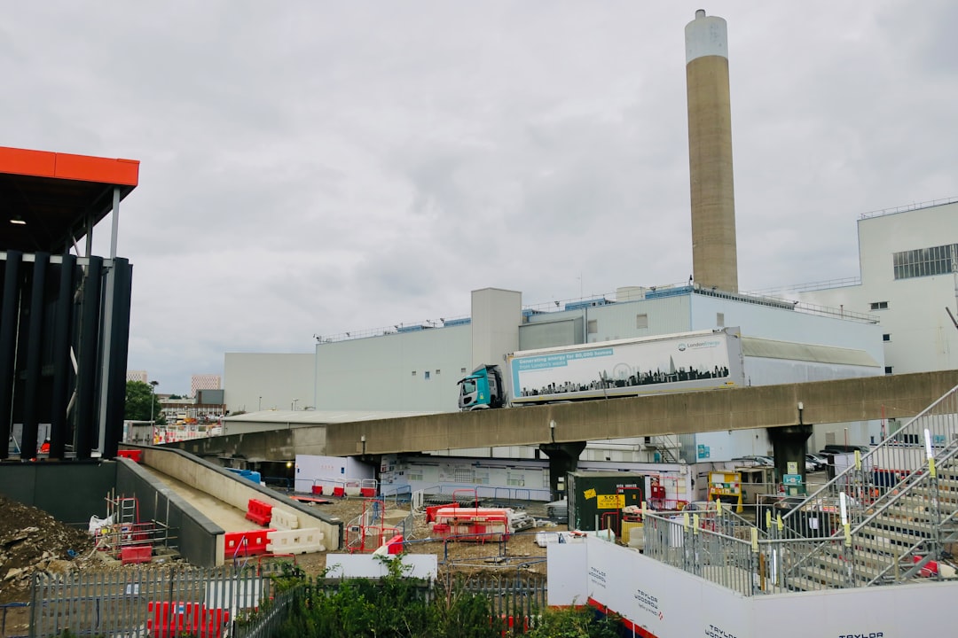 waste-to-energy projects urban infrastructure — municipal incinerator facility with steam plume and recycling equipment visible