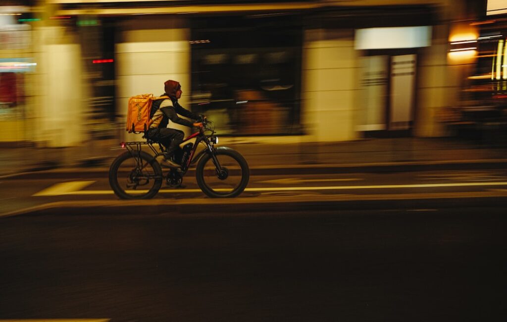 instant commerce urban retail — city street delivery cyclist rushing