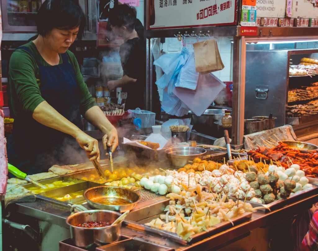global culinary tourism new — Bustling street food market vendor cooking