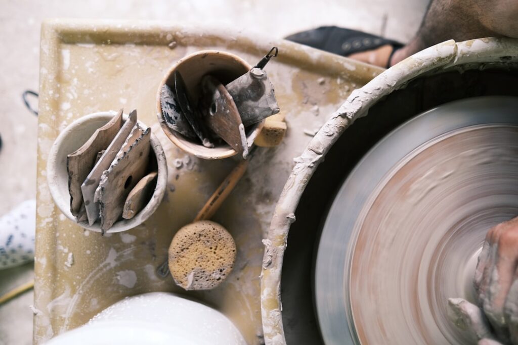 local craft experiences valuable — artisan hands pottery wheel spinning