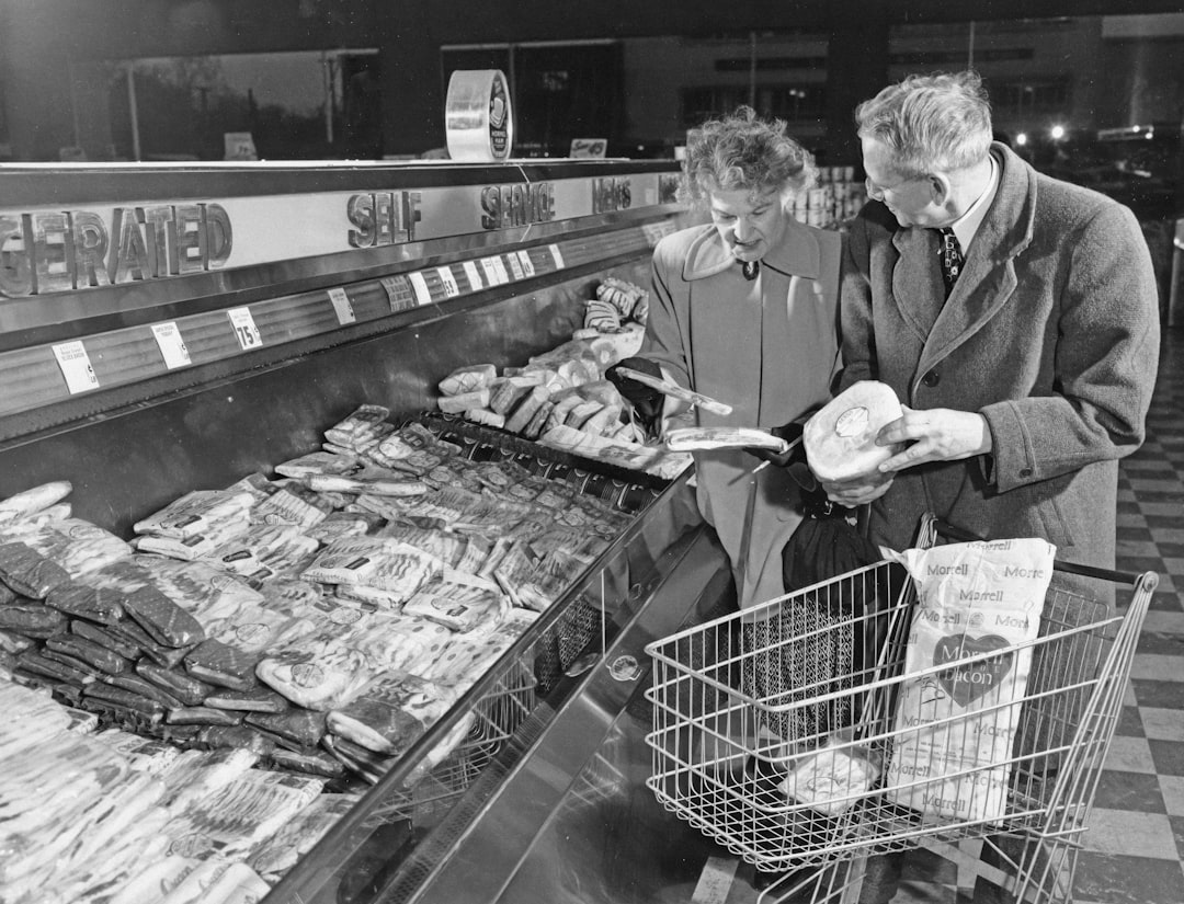 private-label products consumer trust — close-up of shoppers reading nutrition labels in the frozen food aisle at a grocery store