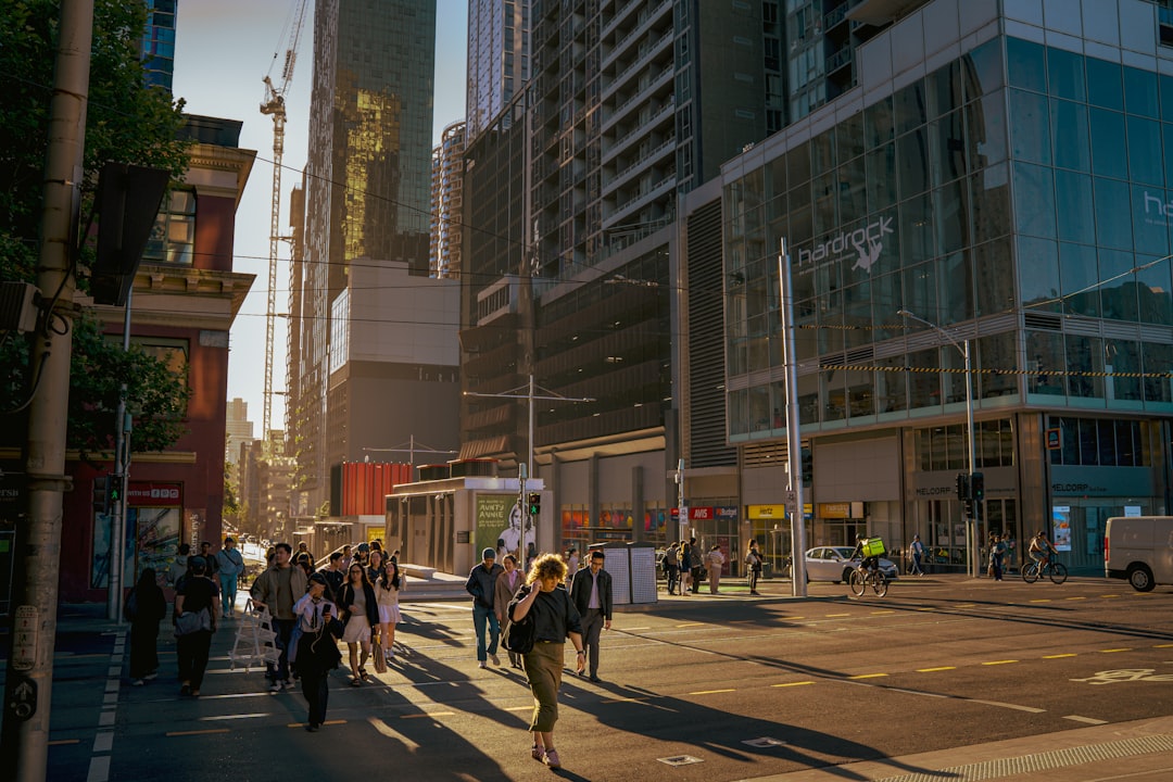 rise mixed-use developments rapidly—glass towers reflecting sunlight over a bustling downtown street with retail storefronts