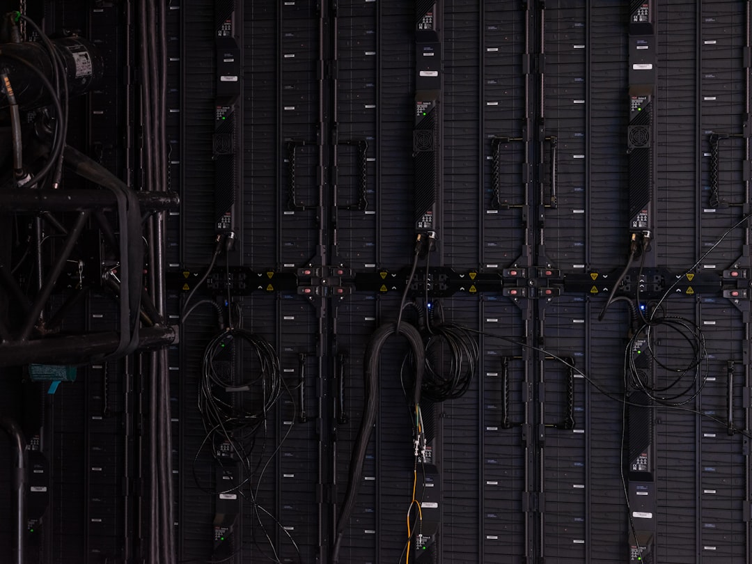 data center real estate — rows of servers with blue LED lights and monitoring dashboard display