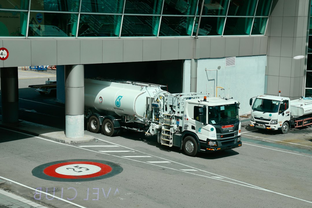 future hydrogen-powered aviation — ground crew refueling hydrogen aircraft at commercial airport with cryogenic tanker truck