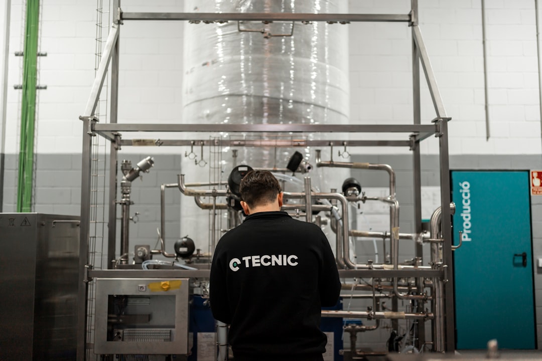 sustainable aviation fuels transform — worker monitoring biofuel production equipment in industrial facility