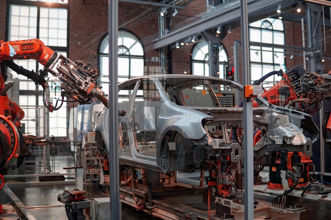 lightweight materials next-generation automobiles — a modern automotive assembly line with composite parts visible on production equipment