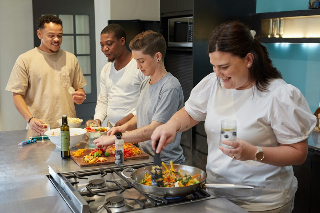 global culinary tourism new — chef teaching cooking class to international tourists in small kitchen
