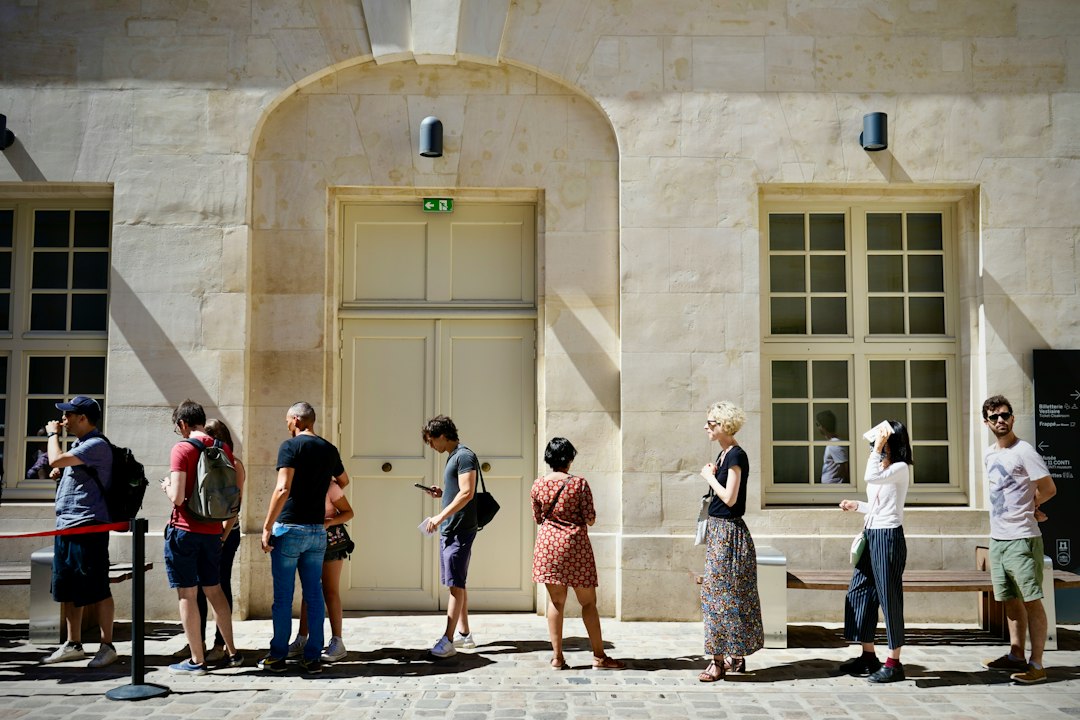 destination management rising tourist — tourists queueing at historic landmark attraction