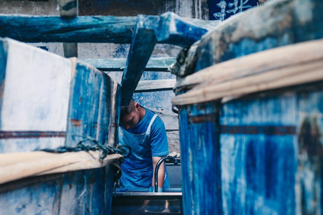 local craft experiences valuable — interior of Japanese textile dye workshop with indigo vats and rolled fabrics